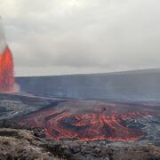 Color photograph of lava fountain and lava flow within crater