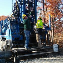 2 men standing on drill rig