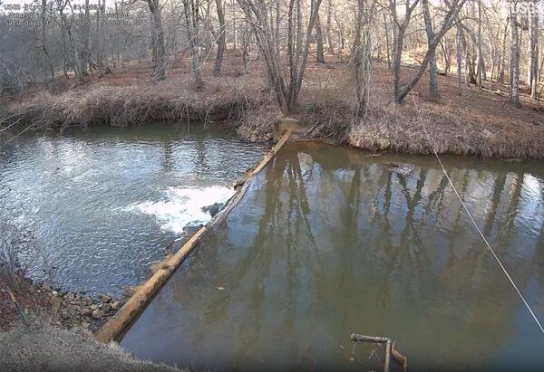 Looking down on the river spilling over a shallow weir from high atop the gage house