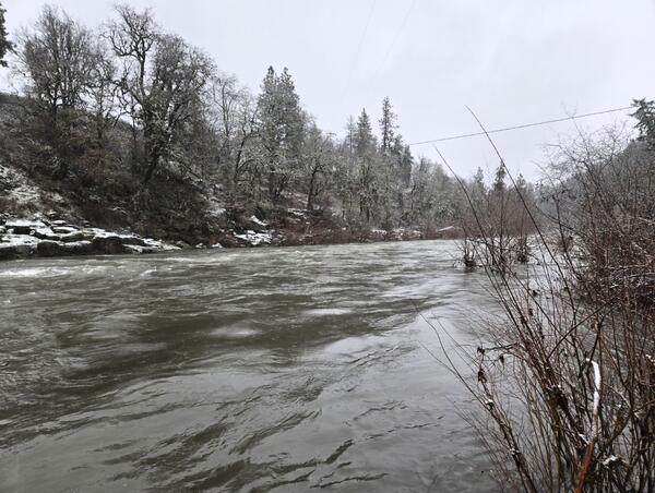 rushing river runs by snow dusted banks