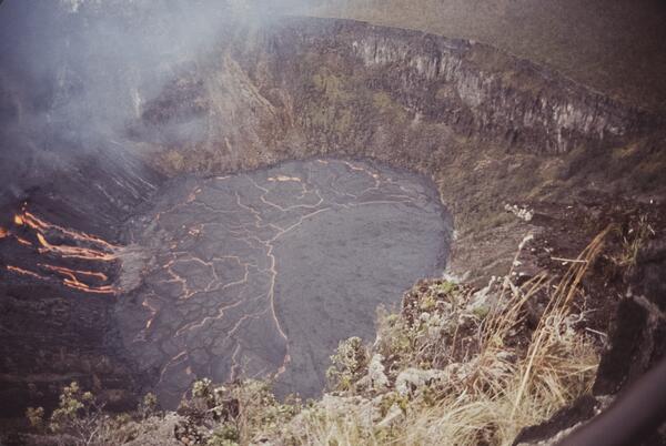 Color photograph of active lava pouring into a crater