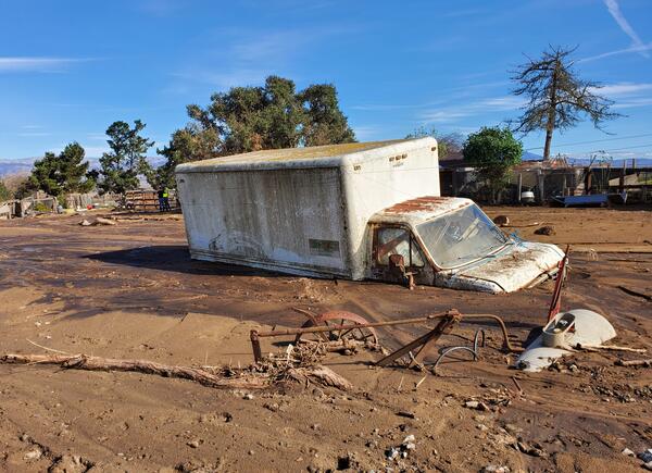 large truck partially buried by mud