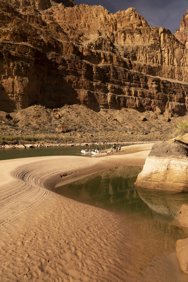 A group of USGS researchers disembark from river research boats on a sandbar along the Colorado River, Grand Canyon