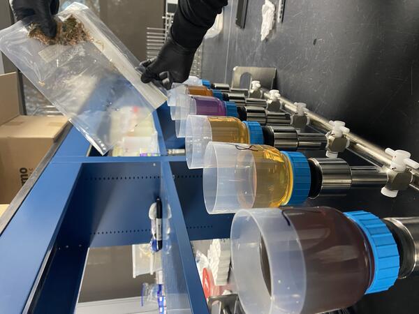 Filtering equipment filled with washings from a chemical process in a line on a laboratory bench