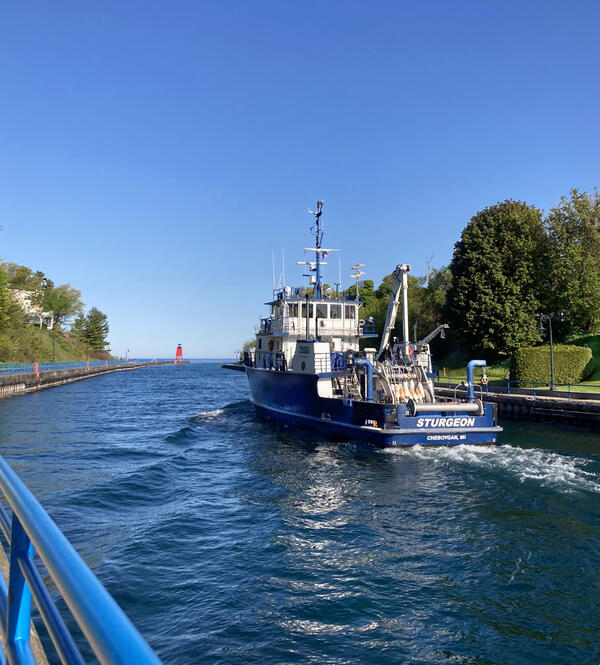 A research vessel moves through a channel toward Lake Michigan