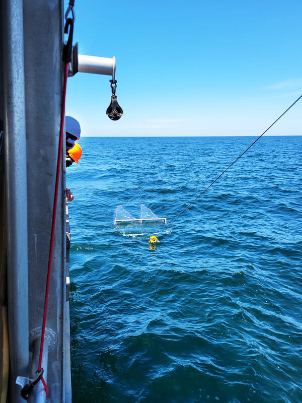 A neuston net being towed alongside a large research vessel in Lake Ontario