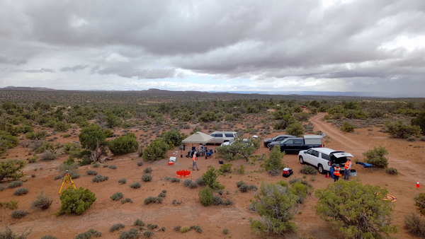 Overhead view taken by drone of a USGS fieldwork site in Moab with multiple cars and a tent shelter