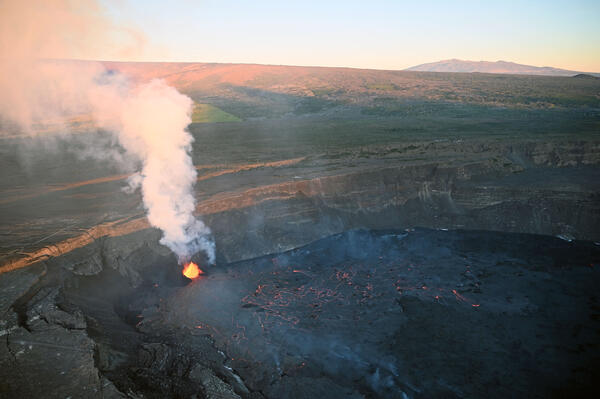 Photograph of eruption, eruption plume, and mountain in the background
