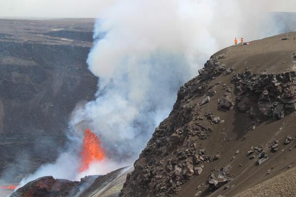 Color photograph of scientists monitoring volcanic eruption