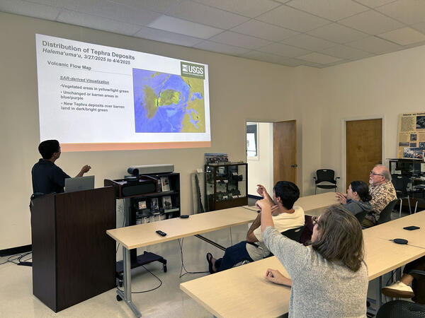 Color photograph of scientists examining data on a screen