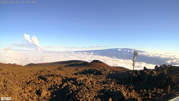 Color photograph of volcanic plume rising above clouds