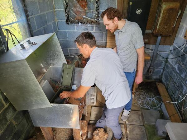 A scientist shows a reporter the various monitoring equipment used to record and transmit water level data.