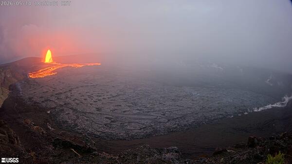 Color photograph of lava fountain and lava flow within crater