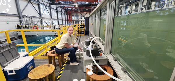 smiling person seated next to sampling equipment