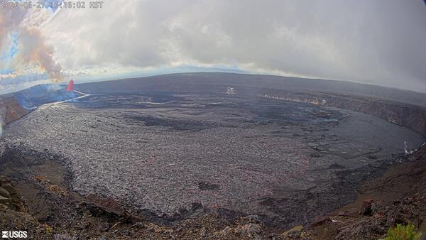 Color photograph of lava fountain and lava flow within volcanic crater