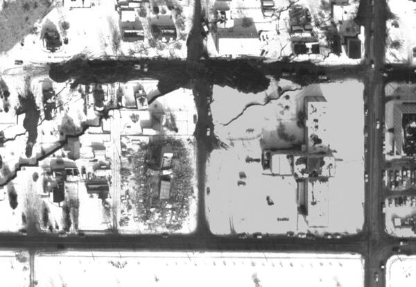 Snow-covered downtown Anchorage with collapsed buildings and large ground cracks after earthquake.