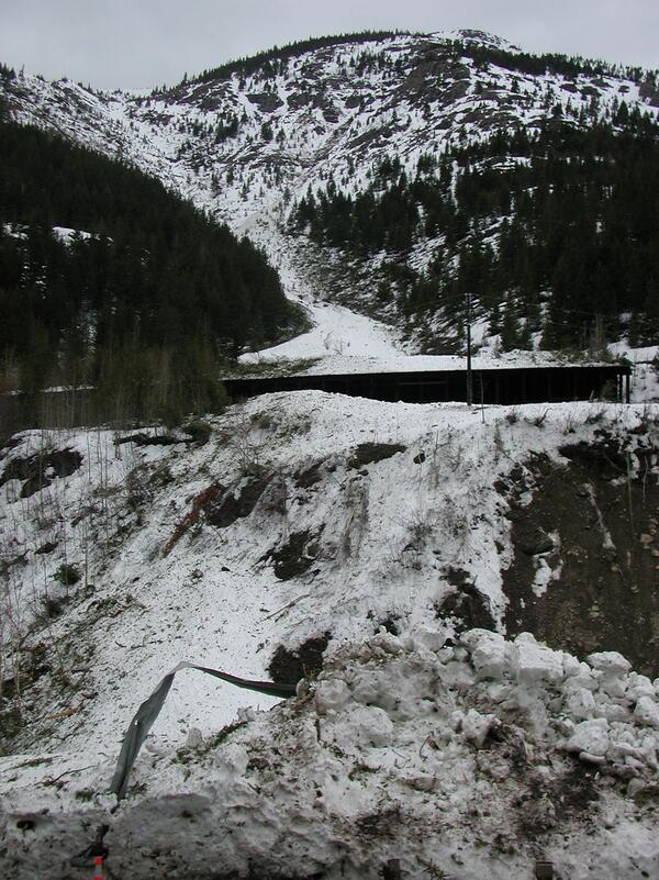 Avalanche debris at end of avalanche path near railway shed