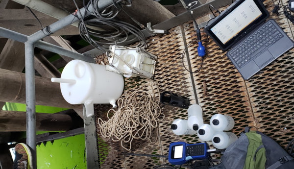 various equipment laid out on an aluminum grate platform. Green water shines below.