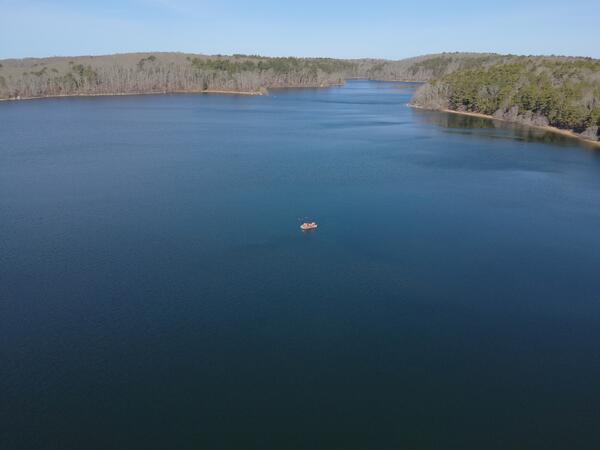 aerial view of pond with small boat on it