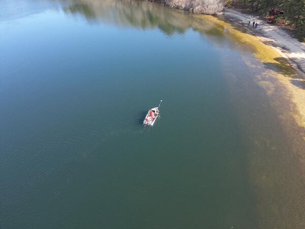 aerial view of pond with small boat on it
