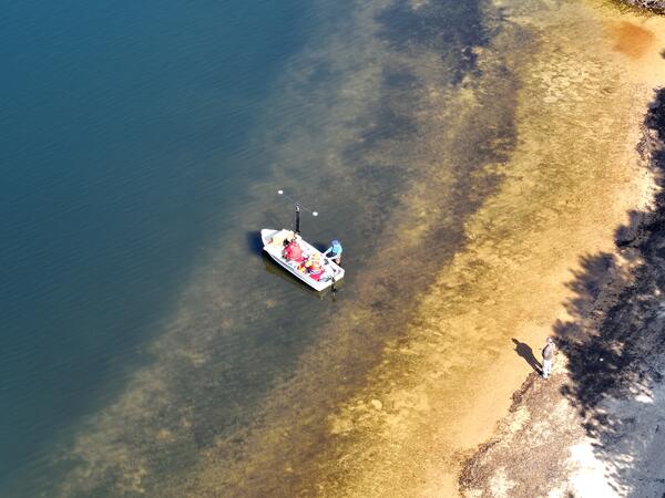 aerial view of small boat near shoreline of pond