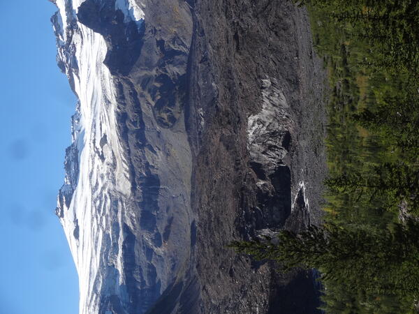 A stream flows from a rock covered glacier