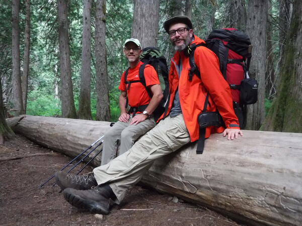 Scientists Carl and Jeff sitting on a fallen tree in Skagit, WA