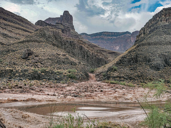 Rocks and mud flow down a canyon watershed in Grand Canyon during a flash flood