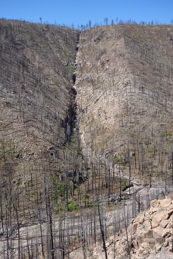 burned hillside with river at the bottom