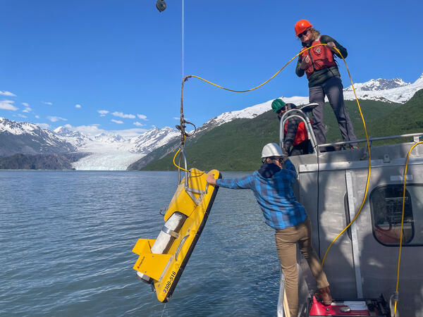 Photo of scientists aboard a research vessel deploying a chirp sub-bottom profiler in Prince William Sound, Alaska