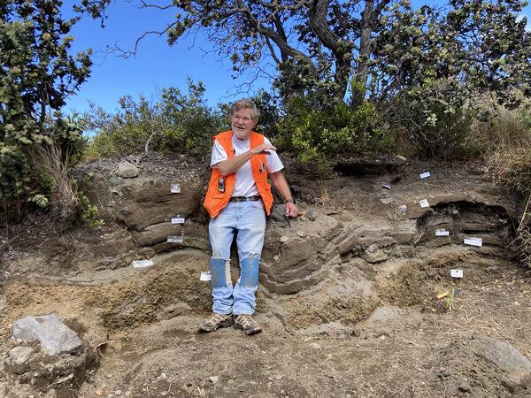 Color photograph of geologist at stratigraphic exposure