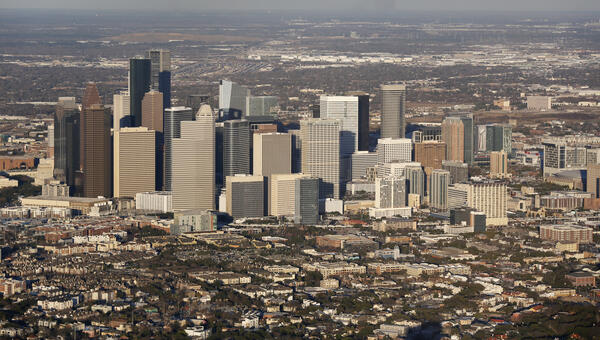Downtown of a city, showing a cluster of skyscrapers, and a flatter surrounding area