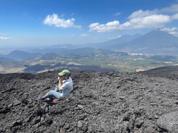 Research Scientist Emily Johnson looks at plagioclase crystals with a hand lens at Pacaya volcano in Guatemala. 