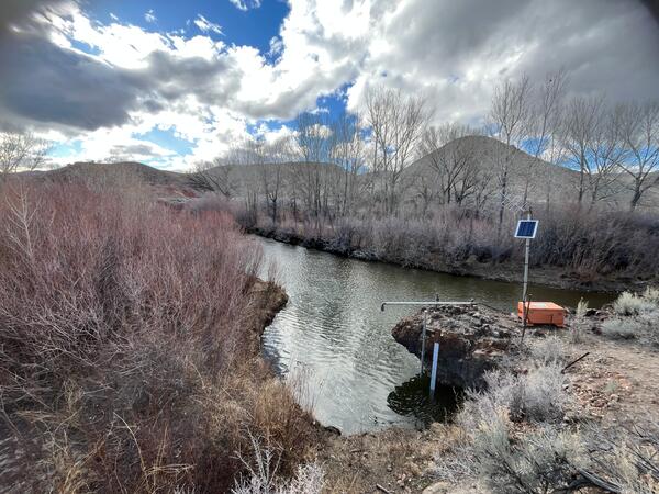 East Walker River flowing past bare trees under cloudy sky  with new streamflow monitoring equipment in foreground.