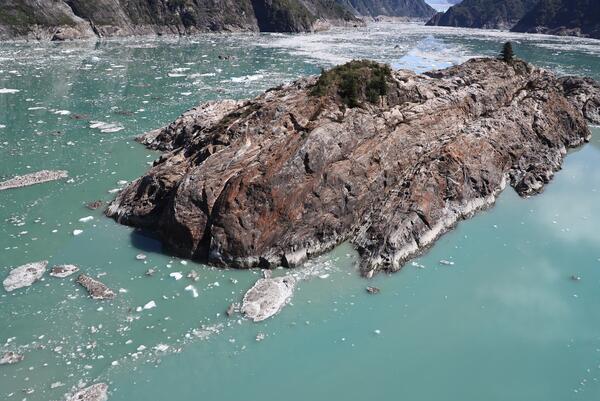 Photo of island in water surrounded by mountains