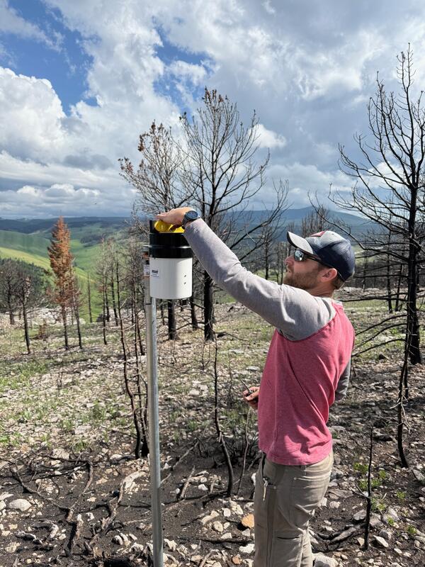 person using a level to measure a rain gage