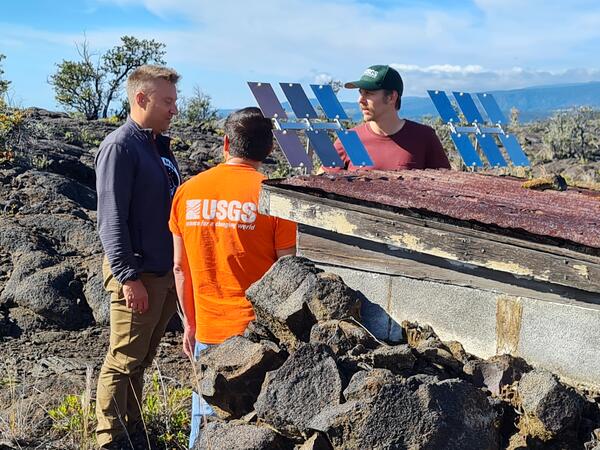 Color photograph of scientists installing experiment in downwind of a volcano