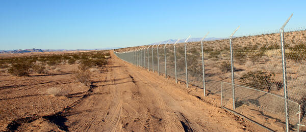 A fenceline along a road runs next to the Gemini Solar Project.