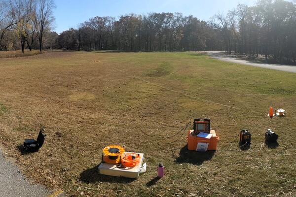 Geophysical survey equipment in a grassy field on a sunny autumn day
