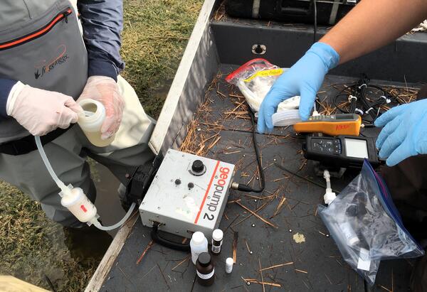 Two scientists filtering water in the field