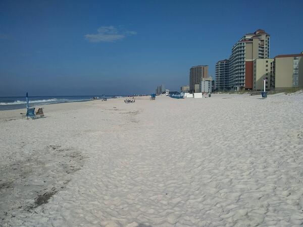 Hotels line an empty white sandy beach in Gulf Shores, Alabama