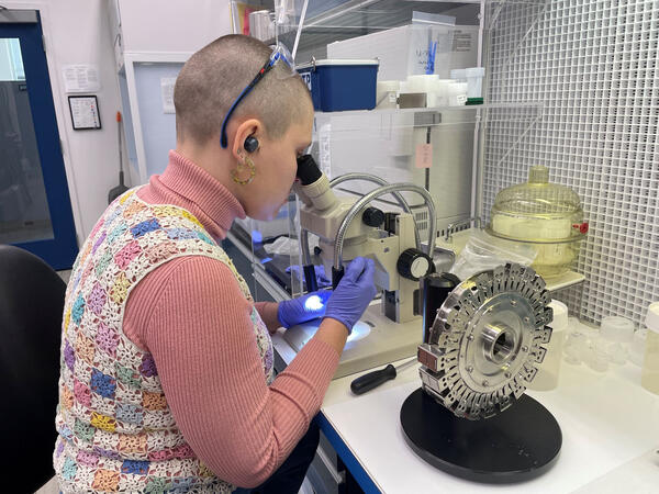 Lab worker loading strontium samples on a turret with 21 individual filament locations
