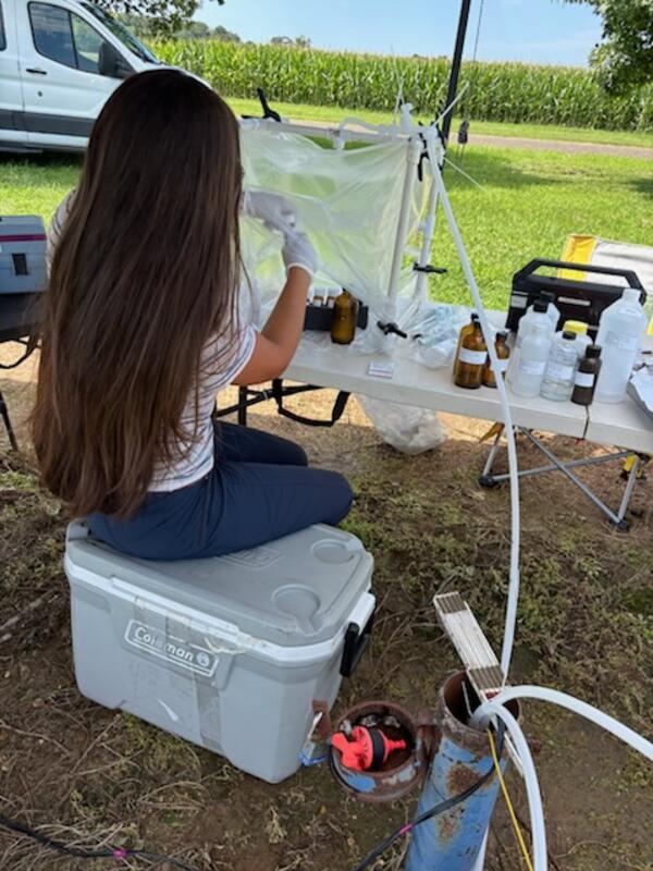Scientist collecting groundwater samples in a sealed workspace while in the field