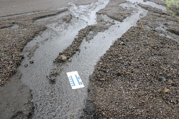 Color photograph of tephra eroded by water and driving on a road
