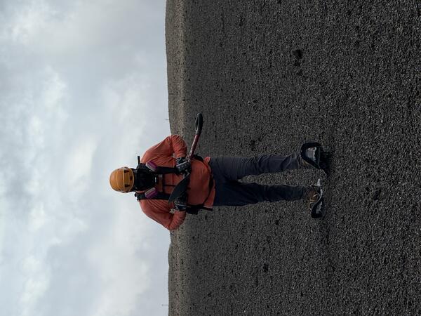 July 10, 2025 — Video of conditions after eruptive episodes downwind of the summit of Kīlauea Color photograph of scientist walking on new volcanic deposit