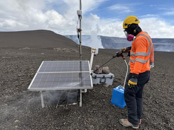 Scientist uses power washer to spray off solar panels