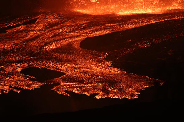 Color photograph of lava flows at night 