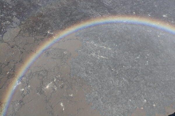 Color photograph of lava flows framed by rainbow