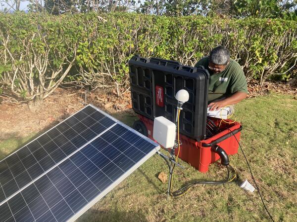 Color photograph of scientist deploying instrument in the field