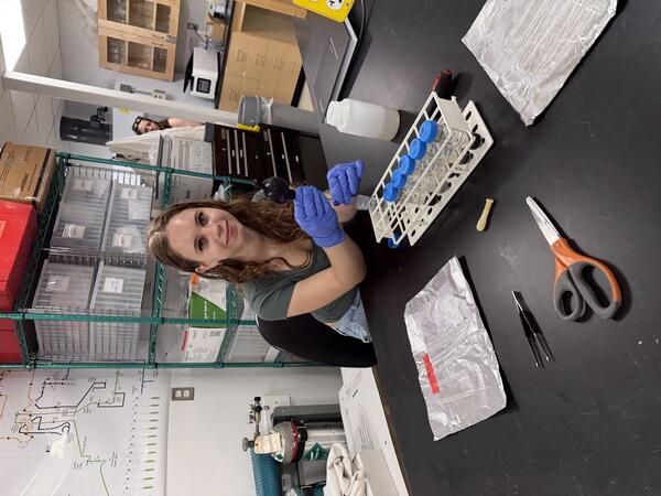 Intern working in a lab smiling to have her picture taken